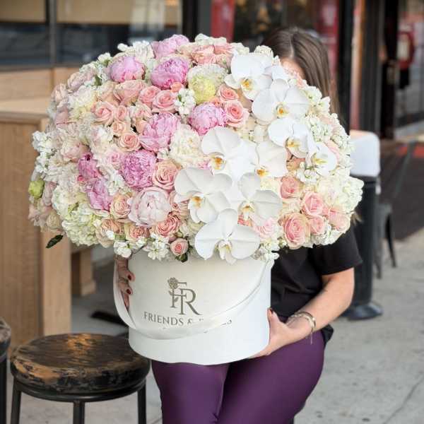 Large hatbox arrangement of pink roses, peonies, and white orchids