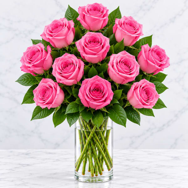 Pink roses arranged in a clear glass vase with visible stems