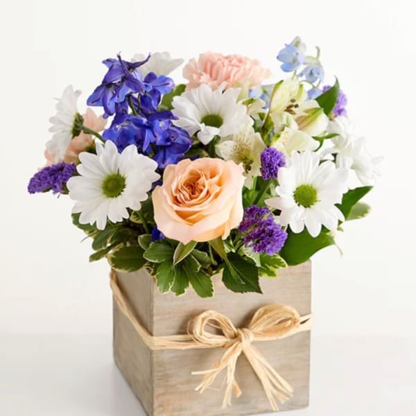 Mixed bouquet in a wooden box with a raffia bow