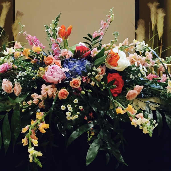 Large floral arrangement with pink, peach, white, and red blooms