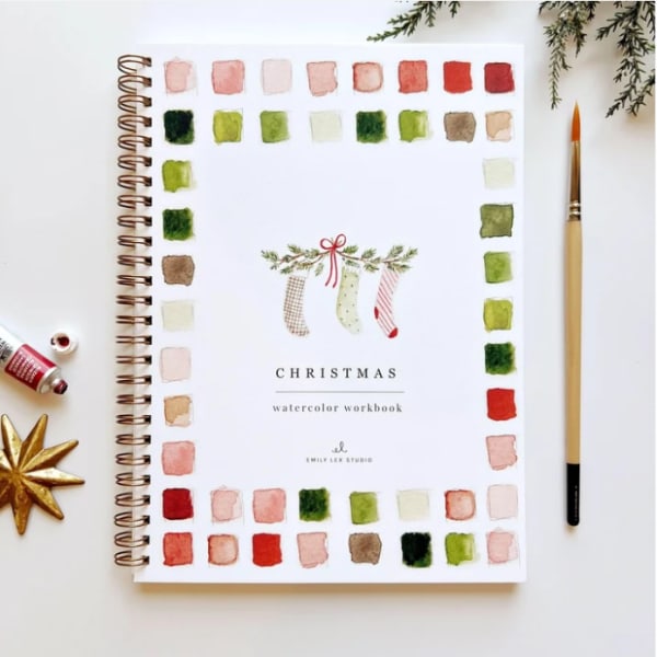 Christmas watercolor workbook with paint swatches and a brush