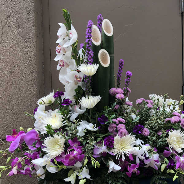 Large floral arrangement with white and purple orchids and white chrysanthemums