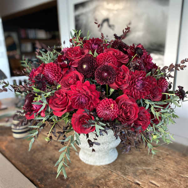 Red floral arrangement in a white vase