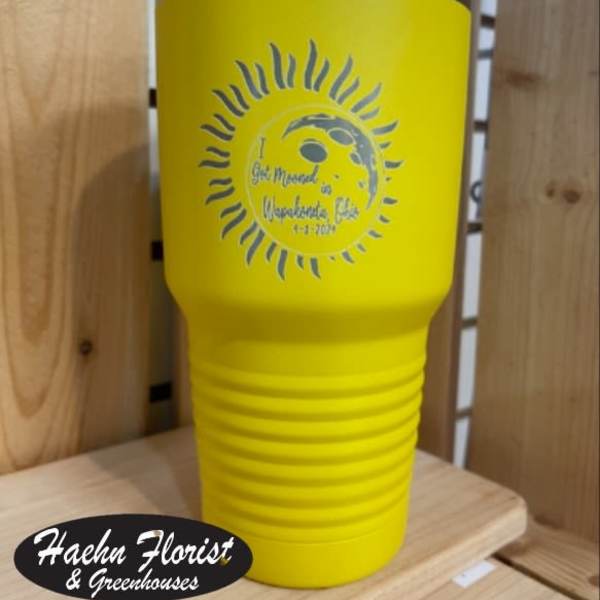 Yellow insulated tumbler with a silver lid and printed sun design
