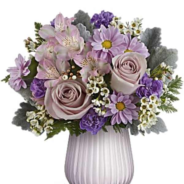 Lavender and white flower arrangement with roses and daisies in a ribbed lavender glass vase
