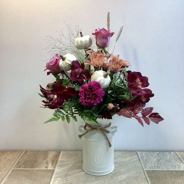Mixed bouquet with pink roses, burgundy flowers, and white pumpkins in a white vase
