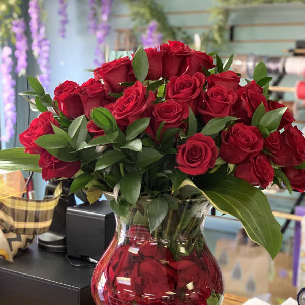 Red roses arranged in a clear glass vase