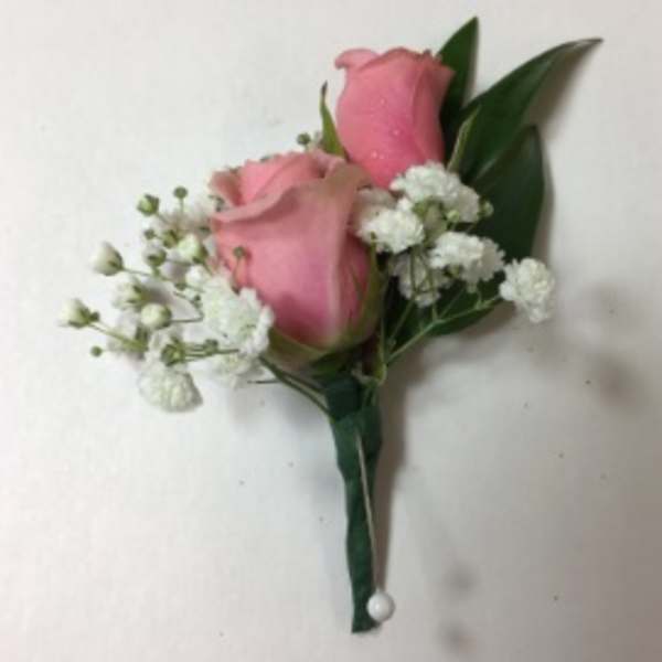 Pink rose boutonniere with white baby's breath and green leaves