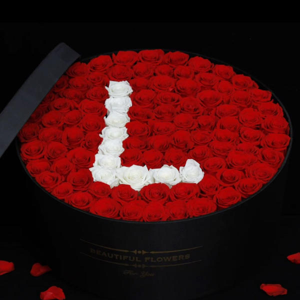 Oval box of red roses with a white rose letter L