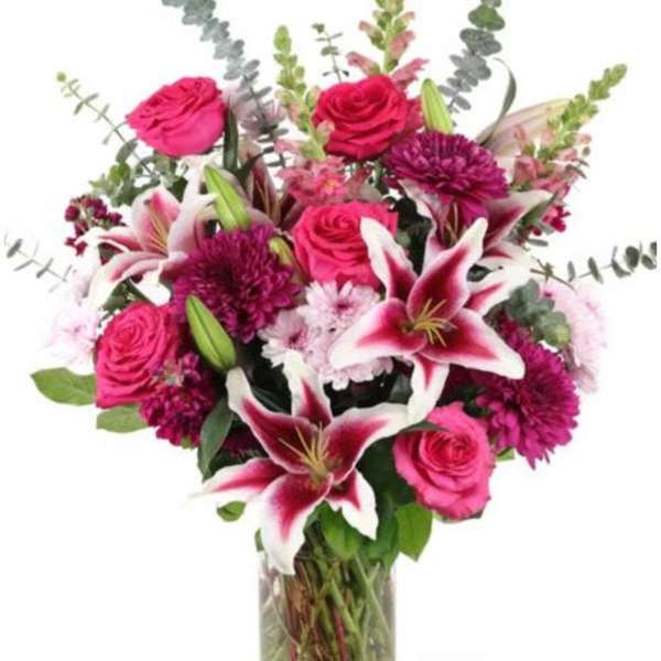 Pink roses and lilies in a clear glass vase