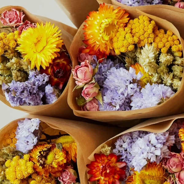 Four bouquets of dried flowers wrapped in brown paper