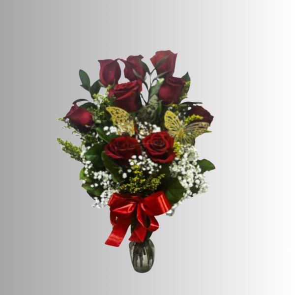 Bouquet of red roses with baby's breath in a glass vase and red ribbon
