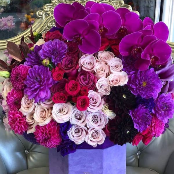 Bouquet of purple orchids, roses, and dahlias in a lavender box