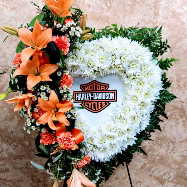 Heart-shaped floral wreath with orange lilies and white chrysanthemums around a Harley-Davidson logo