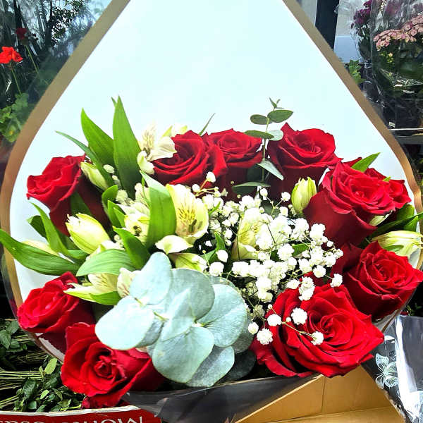 Bouquet of red roses with white alstroemeria in white wrap