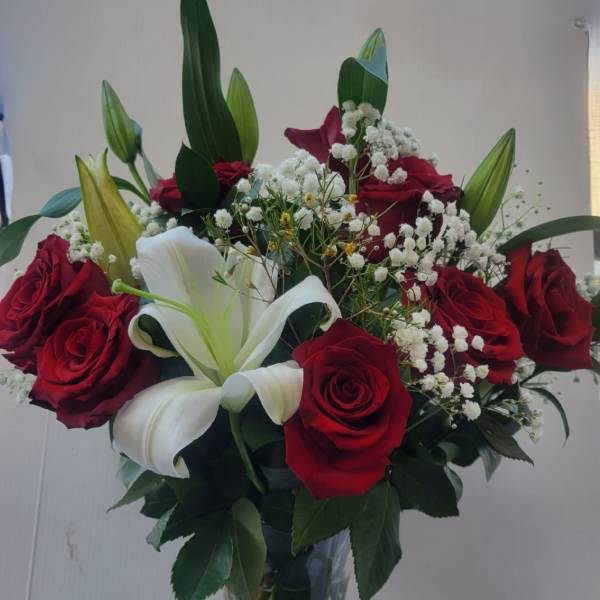 Bouquet of red roses and white lilies in a clear glass vase