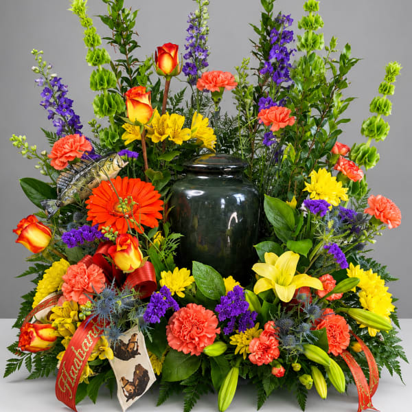 Colorful floral arrangement with a dark urn centerpiece and fish decoration