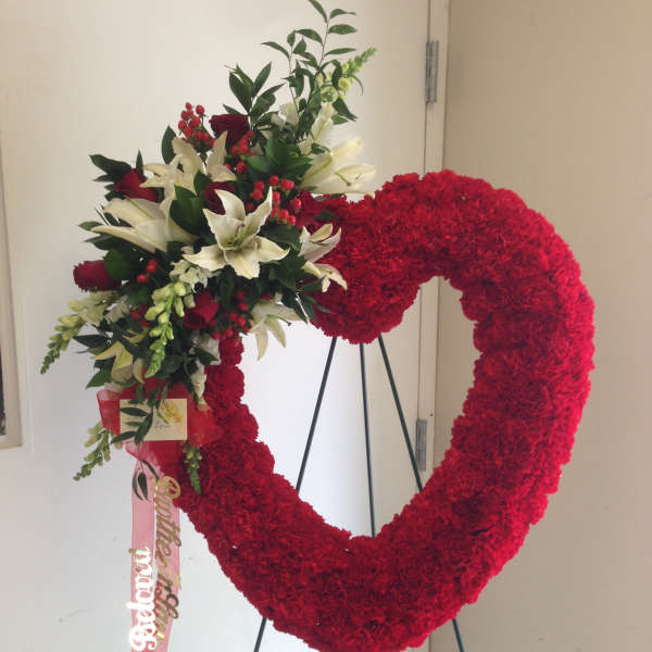 Heart-shaped red floral wreath with white lilies and red roses