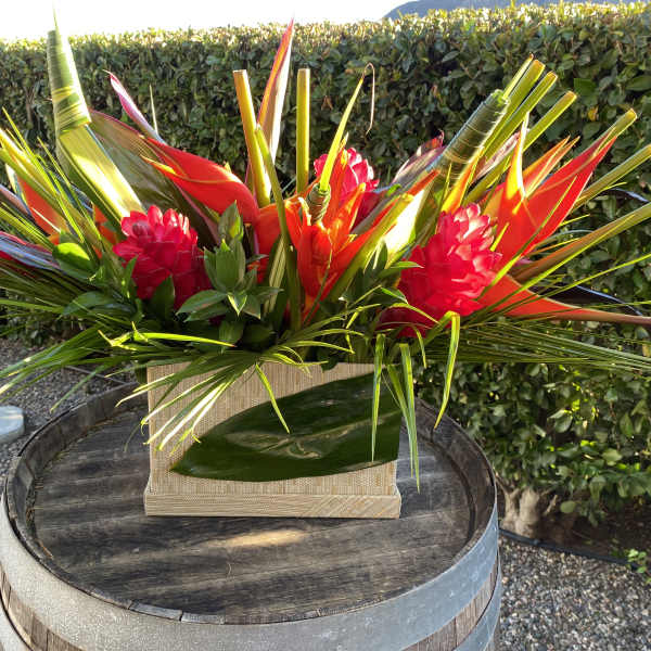 Bright tropical arrangement in a woven rectangular container