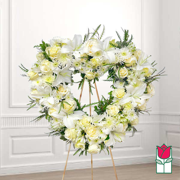 Heart-shaped white floral wreath on a stand