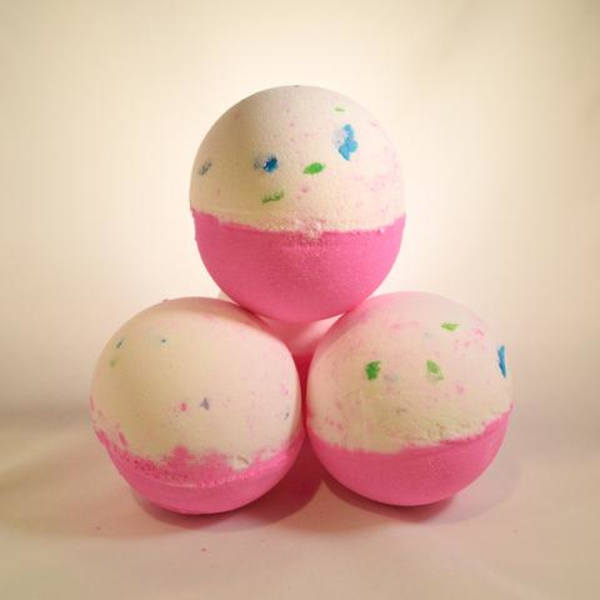 Three pink-and-white bath bombs stacked in a pyramid