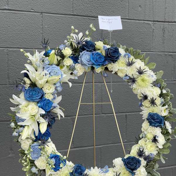 Blue and white floral wreath on a gold stand