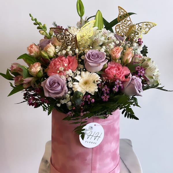 Mixed bouquet in a pink hatbox with roses, lilies, and carnations