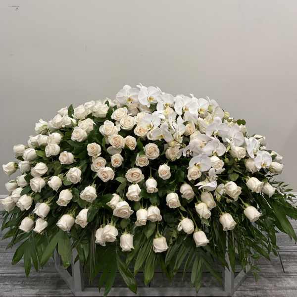 Large white rose and orchid arrangement on a stand