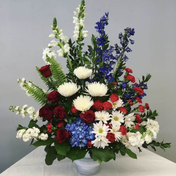 Mixed bouquet in a white vase with red, white, and blue flowers