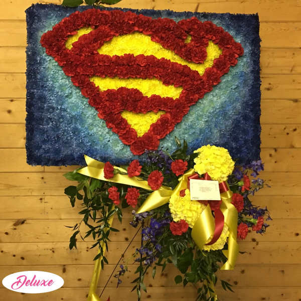 Superman logo made from red and yellow flowers on a blue floral panel
