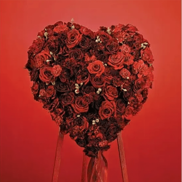Heart-shaped arrangement of red roses on a red background