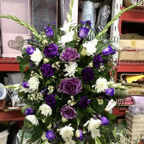 Purple and white floral standing spray on an easel