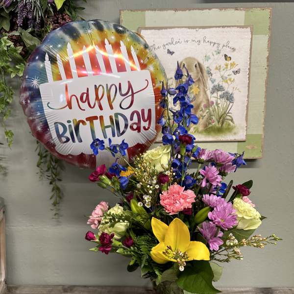 Mixed bouquet in a glass vase with a birthday balloon