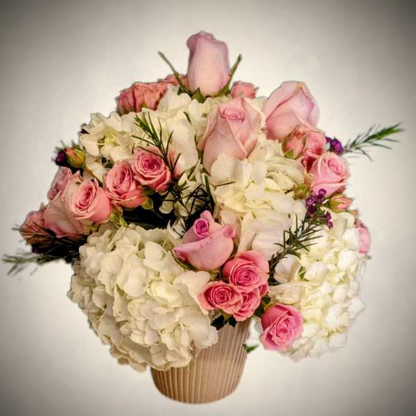 Pink roses and white hydrangeas arranged in a ribbed vase