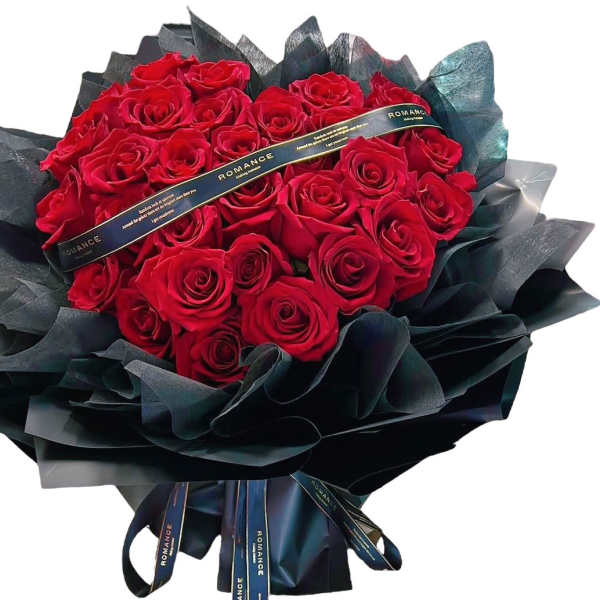 Bouquet of red roses wrapped in dark paper with a ribbon