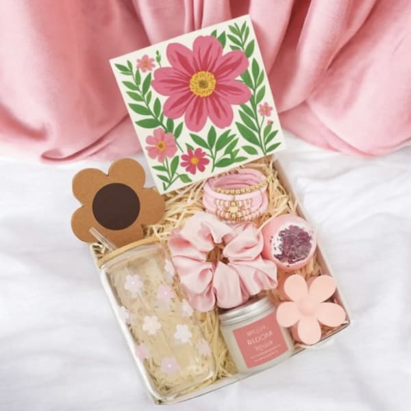 Pink gift box with floral card, scrunchie, jar, and tumbler