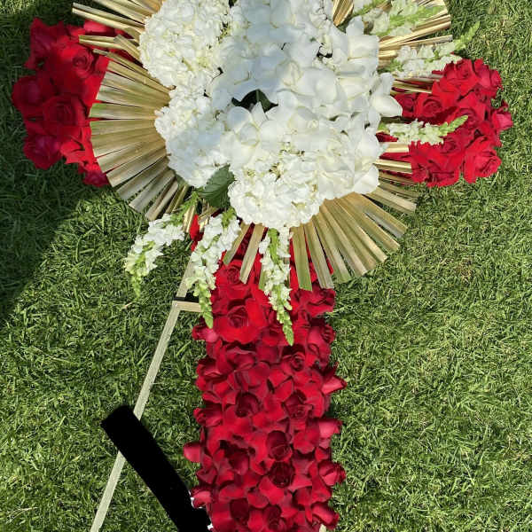 Tall red and white standing easel arrangement with gold fan accents on grass