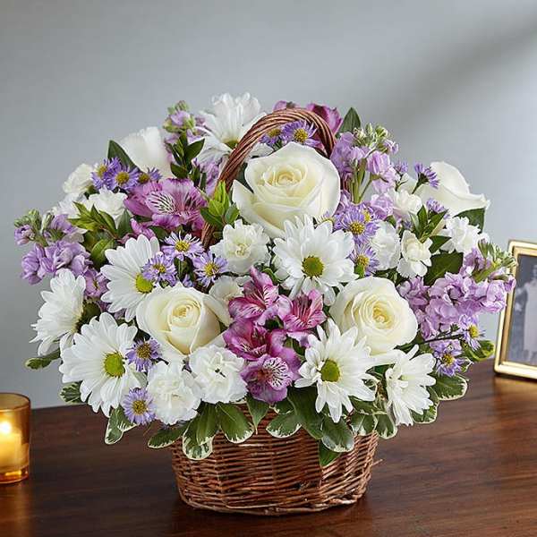 Basket arrangement of white roses, daisies, and purple flowers