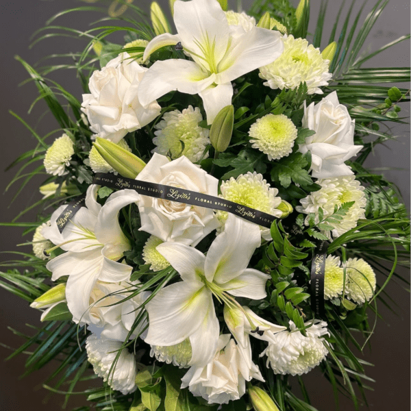 White lilies and roses with pale green mums in a floral spray