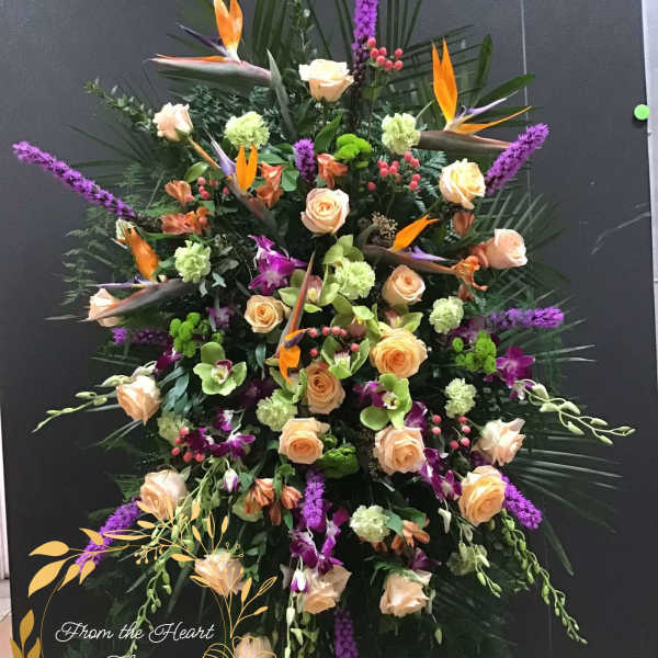 Large tropical floral spray with roses, orchids, and purple spikes