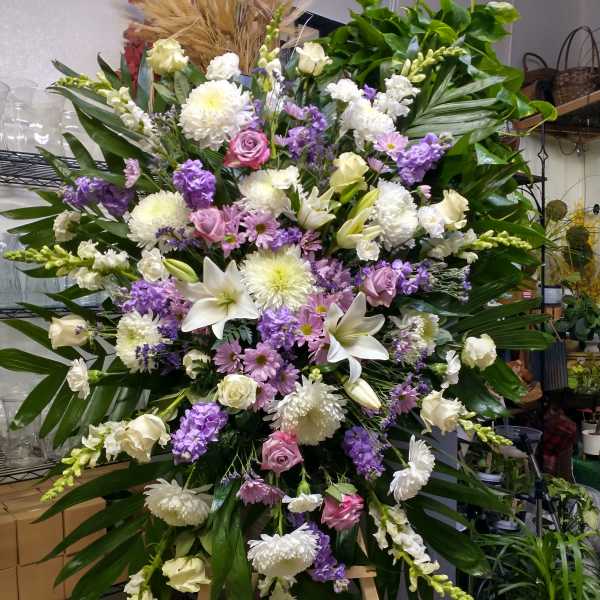 Large standing floral spray with white, pink, and purple blooms