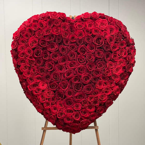 Heart-shaped arrangement of red roses on an easel