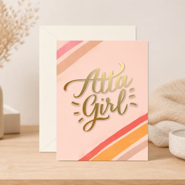 Pink greeting card reading "Atta Girl" with envelope behind it