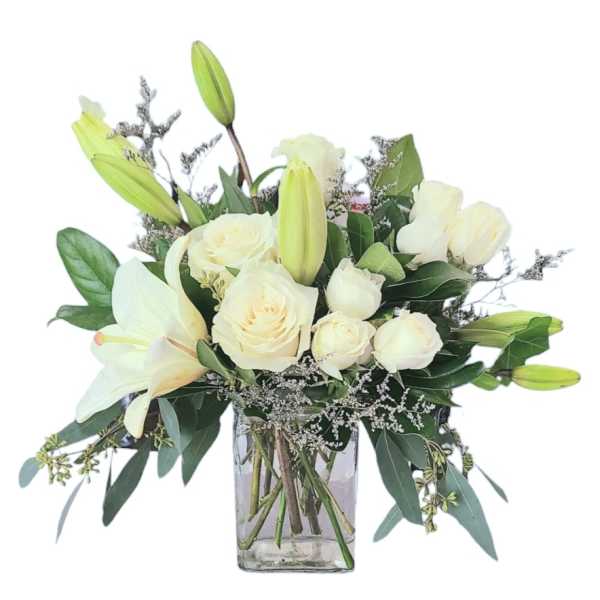 White roses and lilies in a clear glass vase