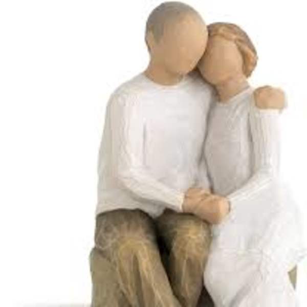 Wooden figurine of a seated couple embracing