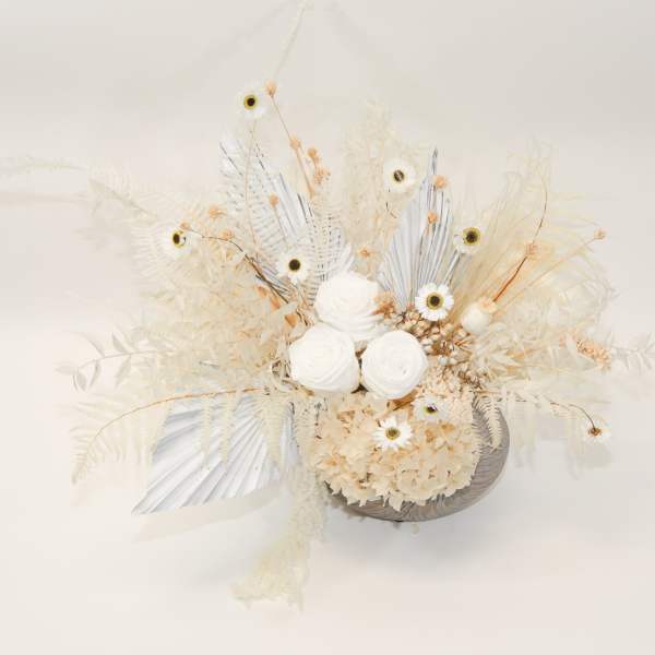Cream-colored floral arrangement with white blooms and dried accents