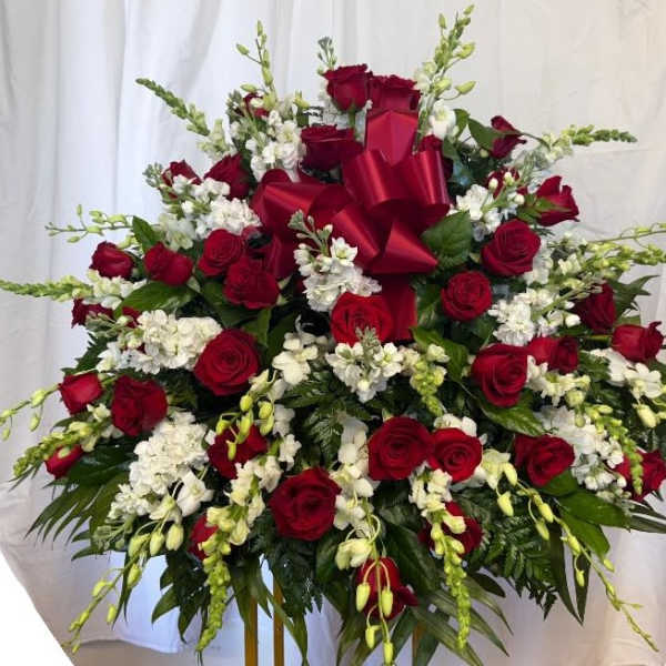 Large red rose and white flower arrangement with a red bow