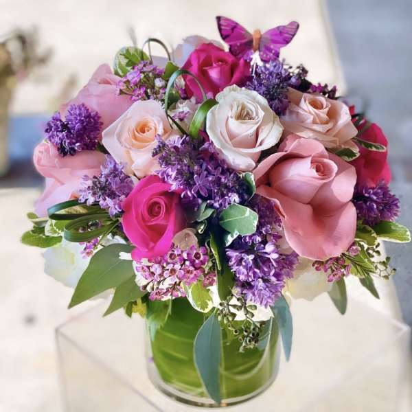 Pink and purple rose bouquet in a clear glass vase