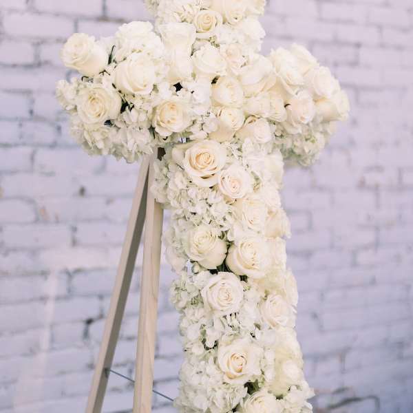 White floral cross on a wooden easel