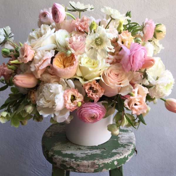Pastel bouquet of roses, tulips, and mixed blooms in a white vase